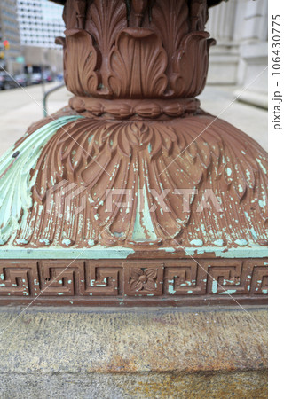 Cast iron, forged antique street lamp with paint peeling off over time in front of the City Hall 106430775