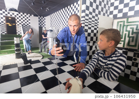 Family tries to get out of the escape room, stylized as a chessboard 106431950
