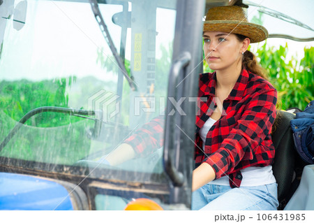 Girl farmer working on a tractor at a orchard Girl farmer working on a tractor at a orchard 106431985