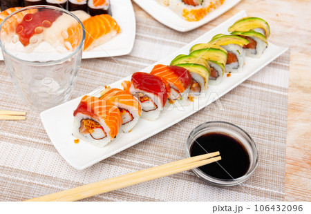 For several guests, Japanese lunch is served - set of uramaki rolls, soy sauce, 106432096