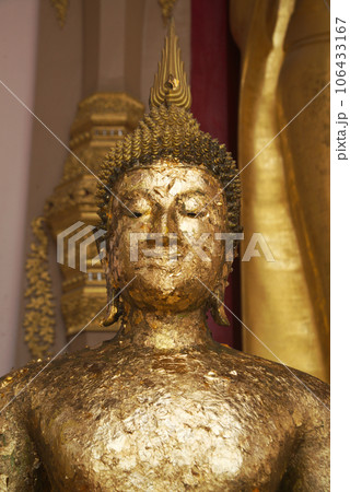 The face of the golden standing Buddha in close-up covered with a sheet of gold paper which shows the respect of the people at Phra Pathom Chedi in Nakhon Pathom Province , Middle of Thailand. The face of the golden standing Buddha in close-up covered with a sheet of gold paper which shows the respect of the people at Phra Pathom Chedi in Nakhon Pathom Province , Middle of Thailand. 106433167