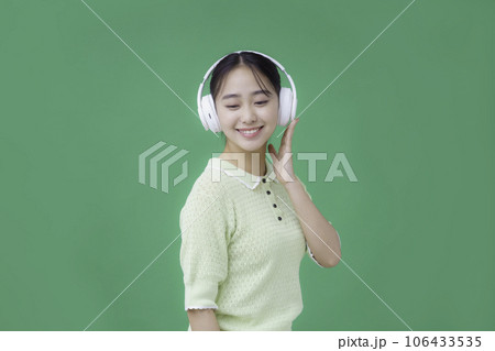 グリーンバックのヘッドフォンをする若い女性 グリーンバックのヘッドフォンをする若い女性 106433535