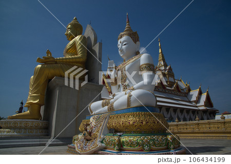 Outdoor large Buddha golden and white in the sitting position beautiful enshrined in front of the church of Wat Charoenratbamrung or Wat Nong Pong Nok temple. Located at Nakhon Pathom in Thailand. 106434199