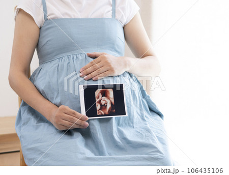 妊婦女性がエコー写真を持っているイメージ 106435106