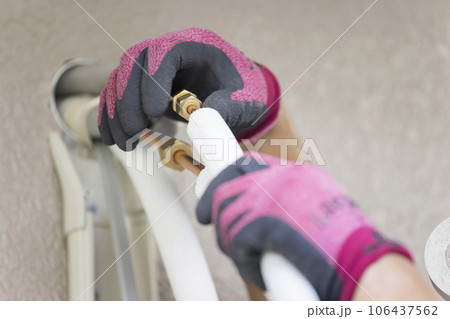 冷媒管を連結する作業員男性手元　エアコン取り付け工事 106437562