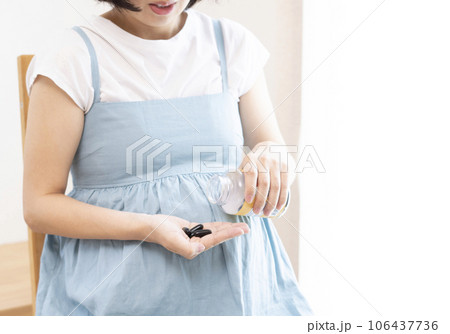 妊婦の女性がサプリメントを摂取するイメージ 106437736