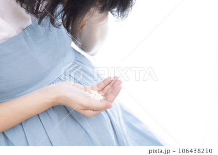 頭を抱えている女性が薬を持っているイメージ 頭を抱えている女性が薬を持っているイメージ 106438210
