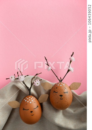 Cute deers made of eggs on fabric background. Brown Easter eggs. Space for your text. Pink background Cute deers made of eggs on fabric background. Brown Easter eggs. Space for your text. Pink background 106439052