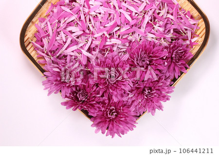 ザルに盛った食用菊の花と花びら 106441211