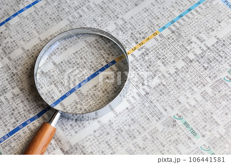 新聞のテレビ欄とガラスレンズの拡大鏡 106441581