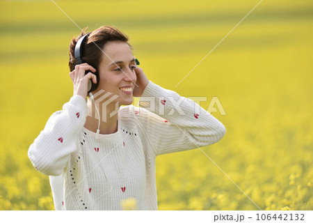 Caucasian girl listening to music with headphone in the outdoors 106442132