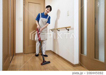 フローリングに掃除機をかける女性 106445092