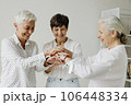 Three confident mature women stacking hands and smiling. 106448334