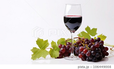 Wineglass with red wine and fresh grape vine next to, isolated on white. 106449008