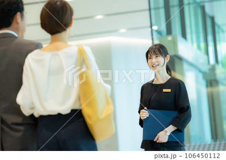 ミドルカップルを案内する受付の女性  ミドルカップルを案内する受付の女性  106450112