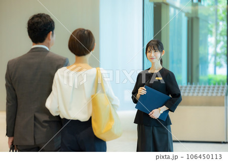 ミドルカップルを案内する受付の女性　 106450113