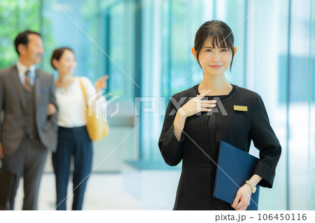 ミドルカップルを案内する受付の女性　 106450116