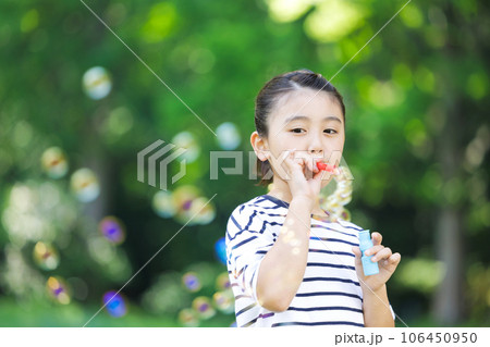 シャボン玉で遊ぶ小学生の女の子 106450950