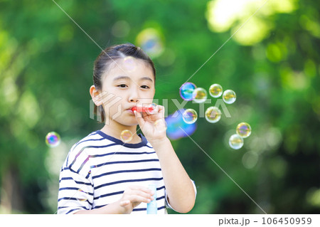 シャボン玉で遊ぶ小学生の女の子 106450959