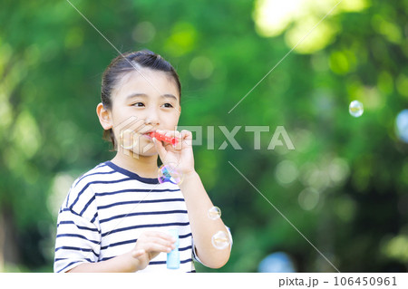 シャボン玉で遊ぶ小学生の女の子 106450961