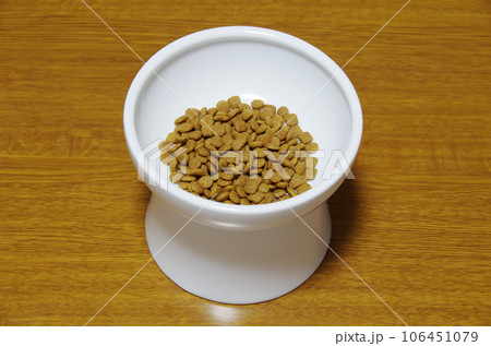 キャットフードの入った白い器を木目のテーブルに置いた状態 キャットフードの入った白い器を木目のテーブルに置いた状態 106451079