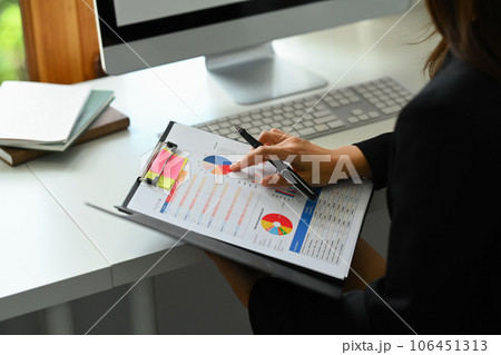 Cropped shot of businesswoman analyzing marketing data, statistics, financial results at desk 106451313