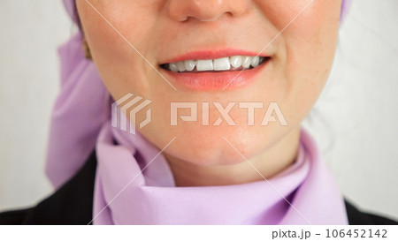 Muslim woman demonstrates toothy smile at white studio wall 106452142