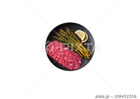 Delicious nutritious breakfast consisting of sliced sausage, asparagus, salt, spices and herbs Delicious nutritious breakfast consisting of sliced sausage, asparagus, salt, spices and herbs 106452358