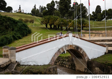 Female tourist taking pictures at the famous historic Bridge of Boyaca in Colombia. The Colombian independence Battle of Boyaca took place here on August 7, 1819. 106452911