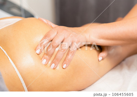 Masseuse hands giving anti-cellulite massage of woman buttocks in beauty salon. Professional beautician giving fat burning massage in spa salon Masseuse hands giving anti-cellulite massage of woman buttocks in beauty salon. Professional beautician giving fat burning massage in spa salon 106455605