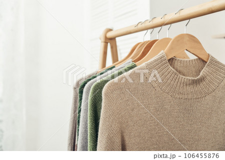Multicolored handknitted sweaters on hangers 106455876