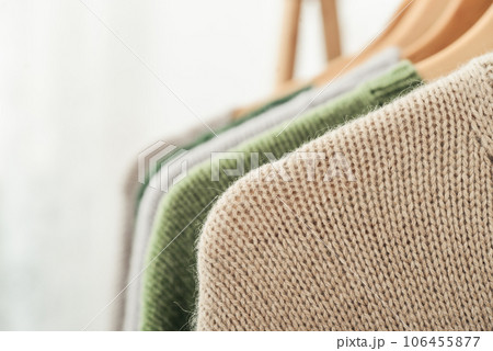 Multicolored handknitted sweaters on hangers Multicolored handknitted sweaters on hangers 106455877