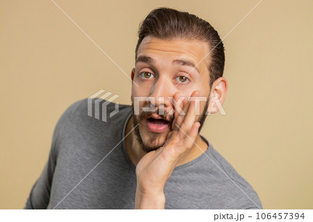 Young lebanese man whisper news rumors holding hands near mouth, share gossip, quiet keep my secrets 106457394