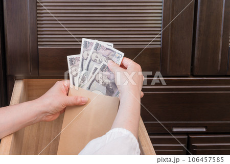 【主婦がたんすの引き出しに封筒入りの一万円札を隠す】 106457585