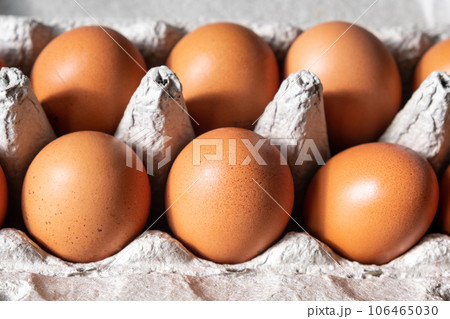 A few brown eggs among the cells of a large cardboard bag, a chicken egg as a valuable nutritious product, a tray for carrying and storing fragile eggs. A full package of eggs, an important food item A few brown eggs among the cells of a large cardboard bag, a chicken egg as a valuable nutritious product, a tray for carrying and storing fragile eggs. A full package of eggs, an important food item 106465030