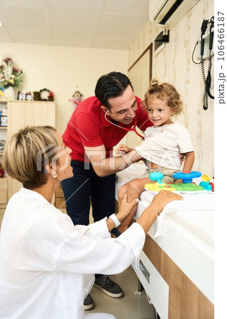 Happy male doctor have fun cheer support boys patients at visit to clinic with mom. Children 106466187
