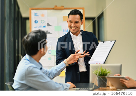 Friendly male manager explaining project details, talking about business to his colleague at meeting 106470510