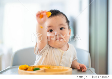 離乳食後期でをつかみ食べをしてご機嫌な生後9か月の赤ちゃん 離乳食後期でをつかみ食べをしてご機嫌な生後9か月の赤ちゃん 106473062
