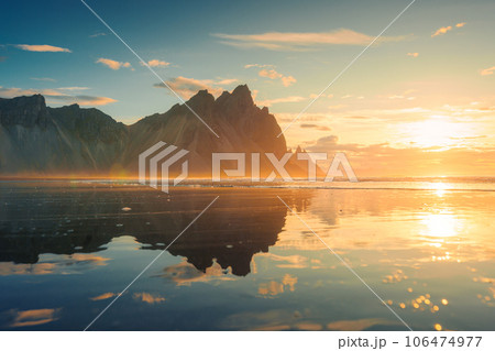 Golden sunrise over Vestrahorn mountain reflection on the beach in Stokksnes peninsula at Iceland 106474977