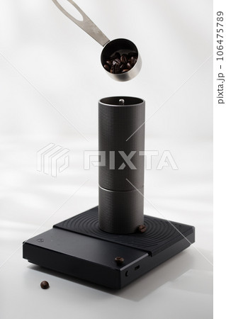Putting coffee beans into a manual coffee grinder. 106475789
