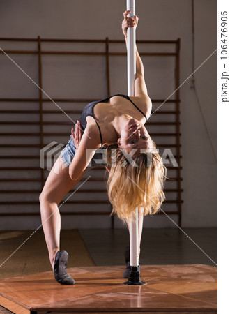 Sexy girl in denim shorts performs a dance with a pylon Sexy girl in denim shorts performs a dance with a pylon 106476906