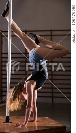 Attractive sports girl dancer engaged on pylon at gym 106476969