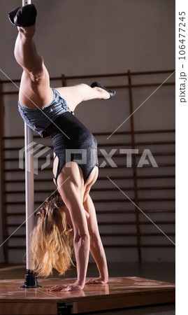 Young woman in denim shorts practicing pole dancing Young woman in denim shorts practicing pole dancing 106477245