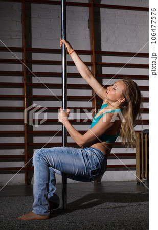 Woman on pylon in lightless studio Woman on pylon in lightless studio 106477576