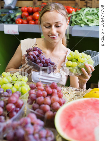 Woman customer buying sweet ripe grapes on marketplace Woman customer buying sweet ripe grapes on marketplace 106477709