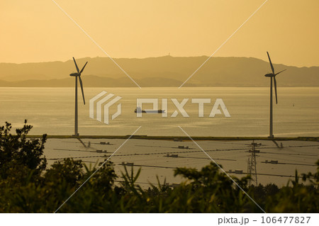 夕方の海沿いに立ち潮風を受ける風力発電の風車 夕方の海沿いに立ち潮風を受ける風力発電の風車 106477827