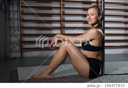 Woman sitting near pylon in dark studio 106477833