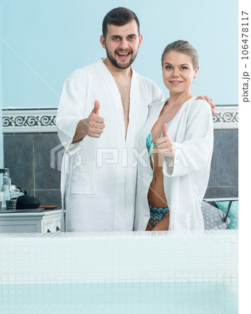 Couple in bathrobes near pool 106478117