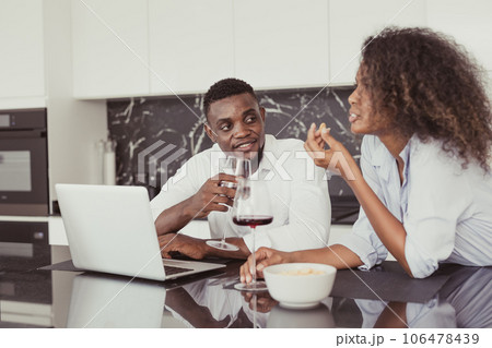 Black people couple wine drink dates talking together relax meeting in kitchen home vintage color tone Black people couple wine drink dates talking together relax meeting in kitchen home vintage color tone 106478439
