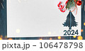 Christmas 2024 background. White paper with fir-tree shape cut for new year 2024 card on wooden table 106478798